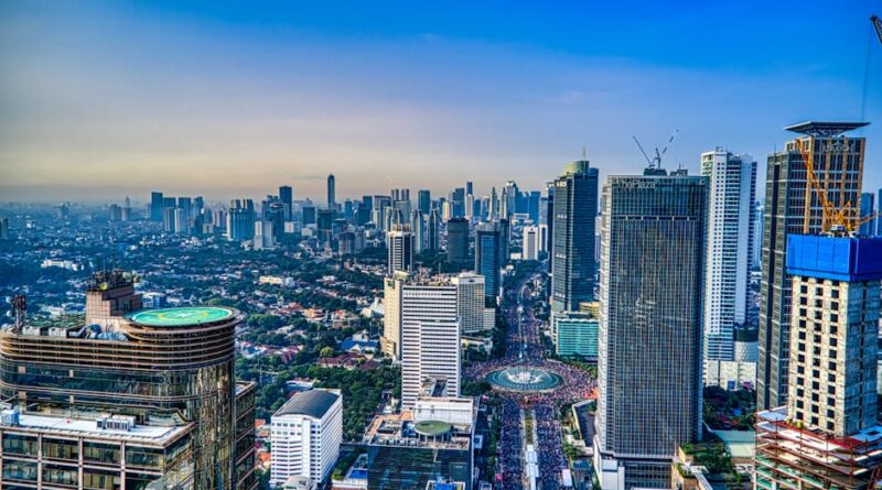 A breathtaking aerial view of Jakarta's urban skyline during the day, showcasing skyscrapers and city life.